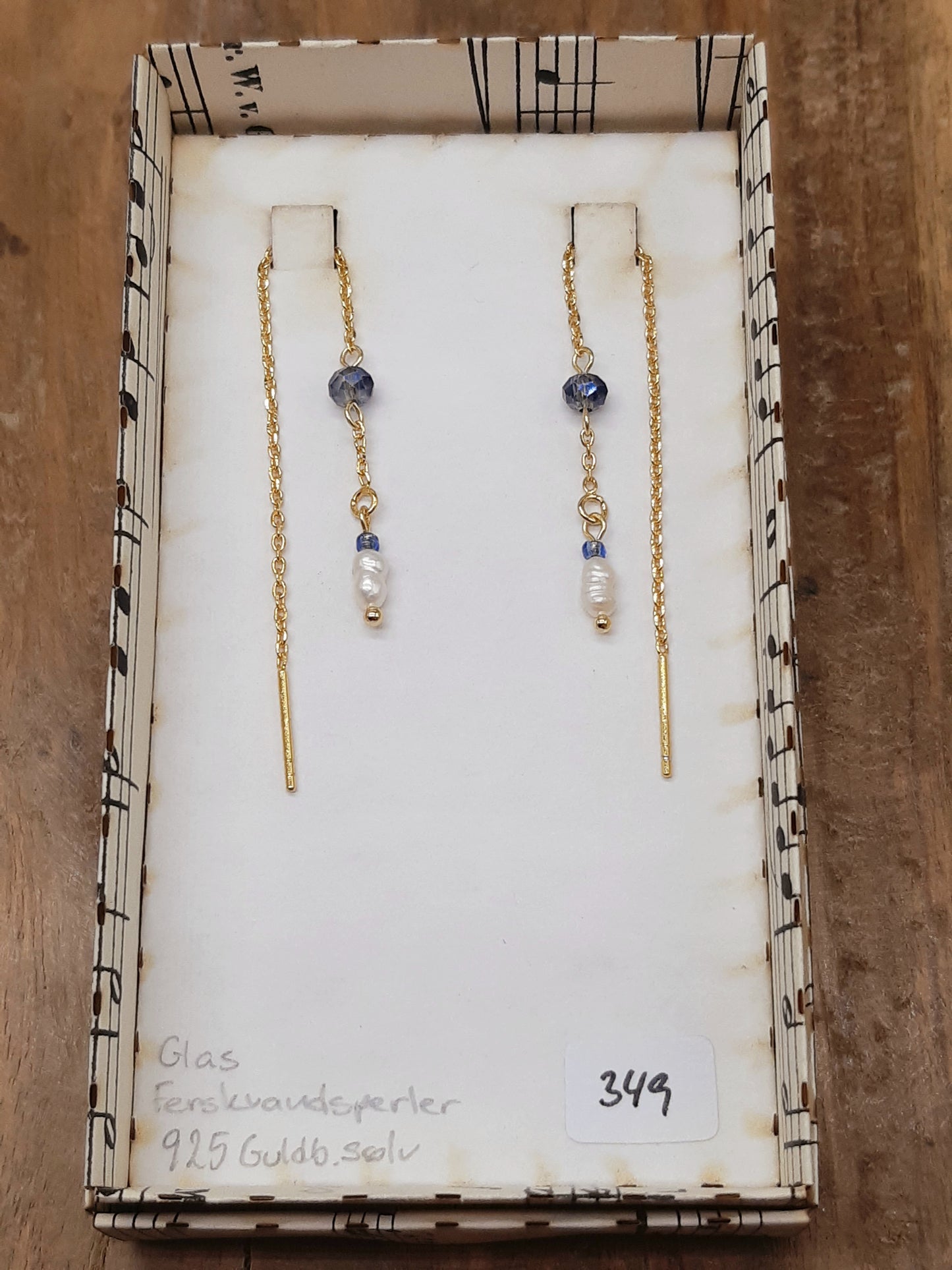 Blå glas og hvid ferskvand øretråd