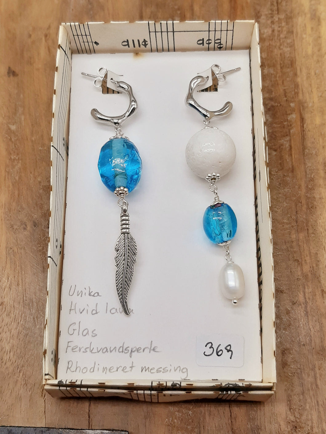 Hvid lava og lyseblå glas med fjer. Asymmetrisk