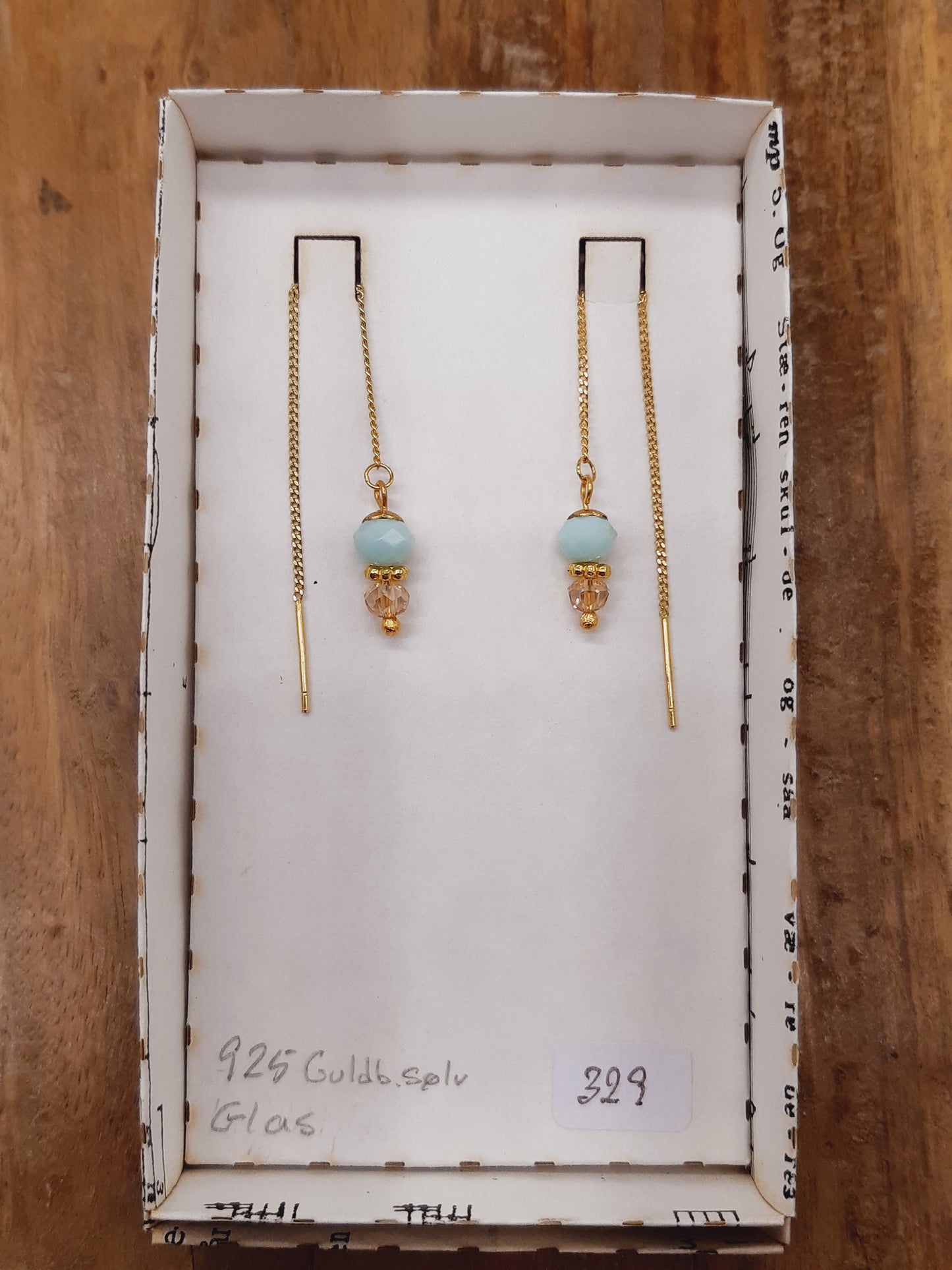 Lyseblå og gylden facetglas i tråd