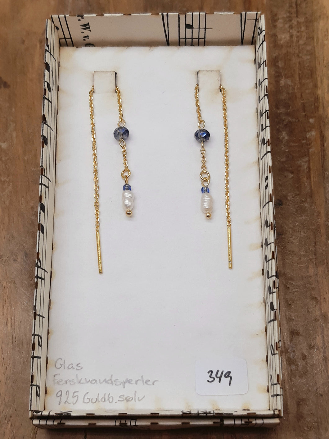 Blå glas og hvid ferskvand øretråd