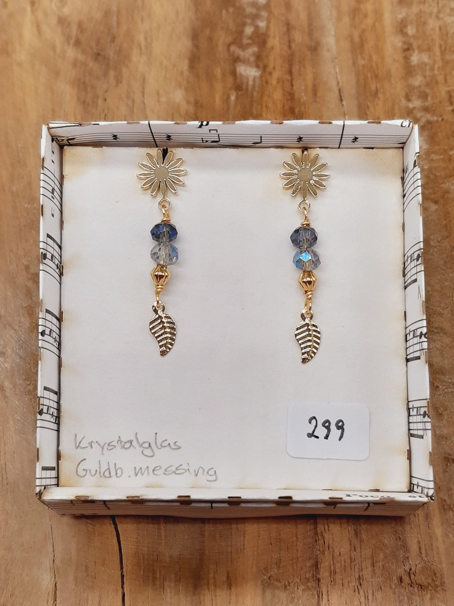 Blå facetglas med blad i blomster-stikker